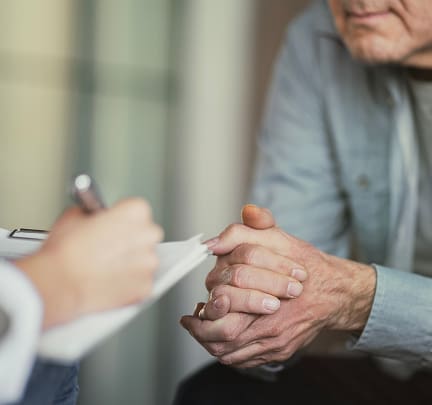 A person listens attentively to an elderly woman sharing her thoughts.